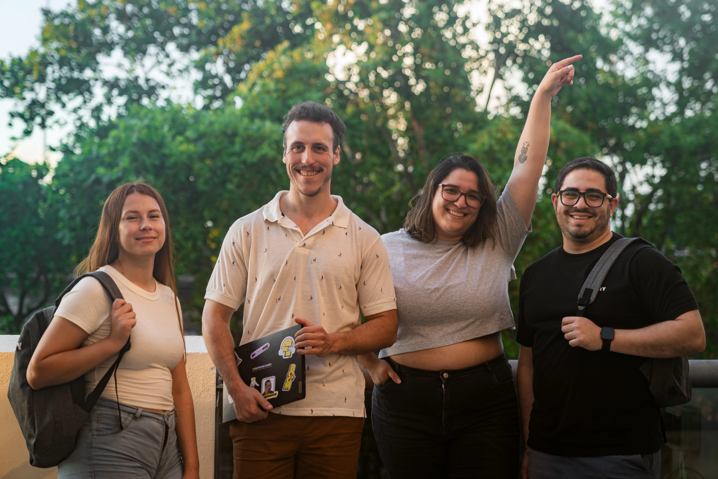 Four Henry graduates smiling together outdoors