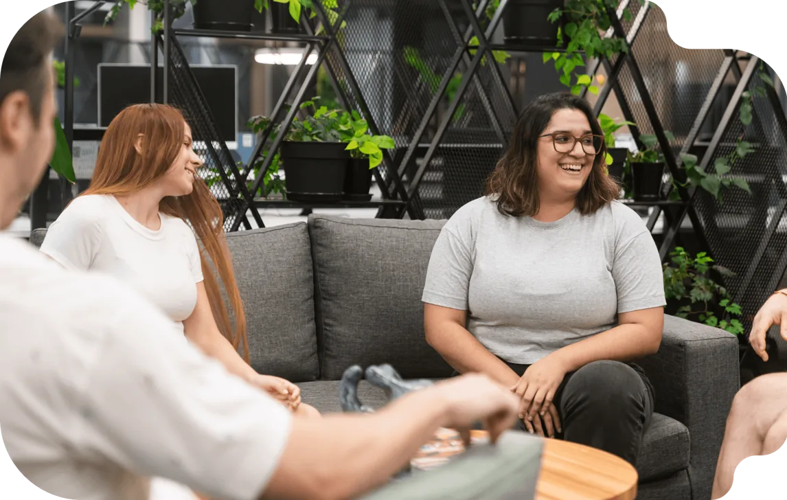 Henry graduates talking on a couch in a coworking space